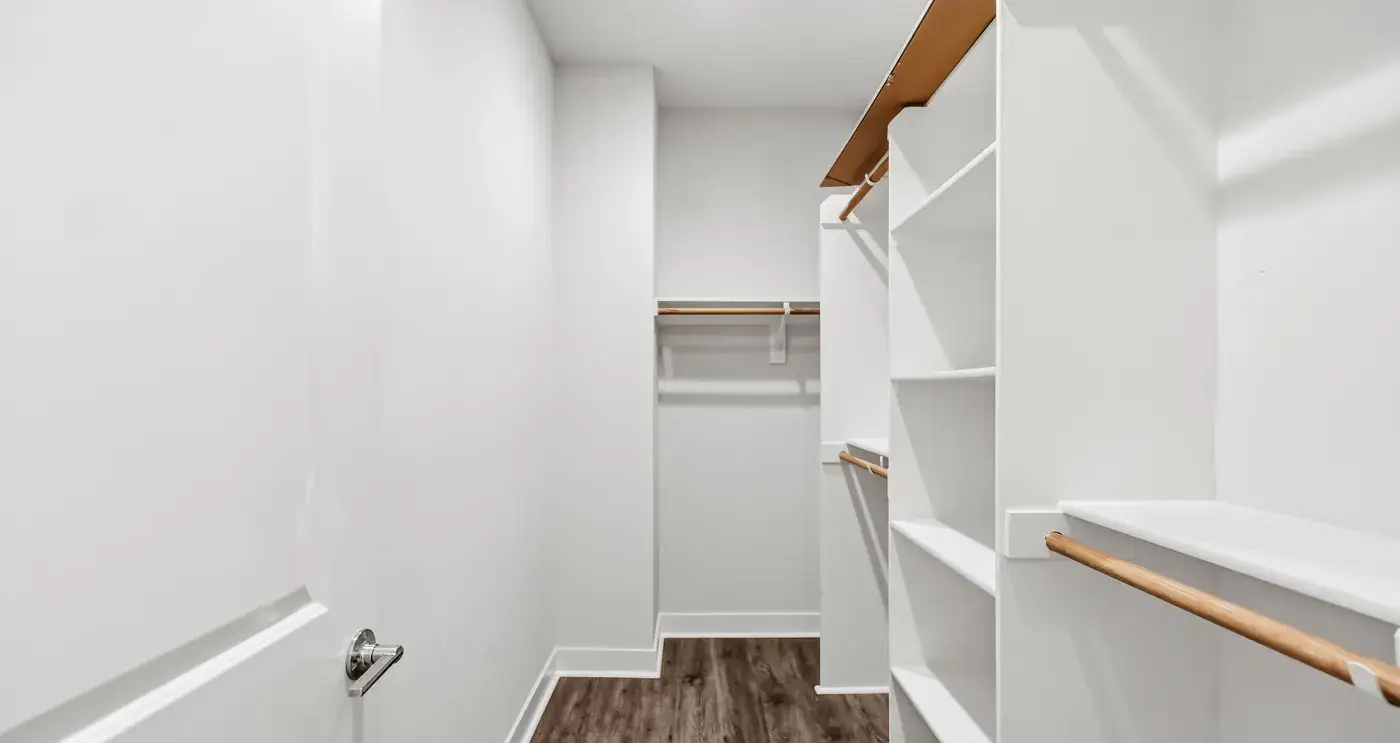 The walk-in closet with white built-in shelving