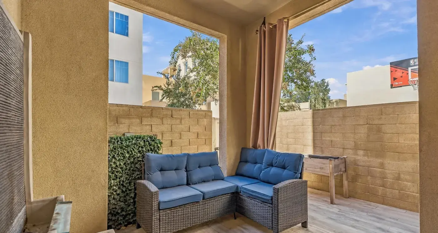 The covered patio in the walled courtyard, with a wicker sectional
